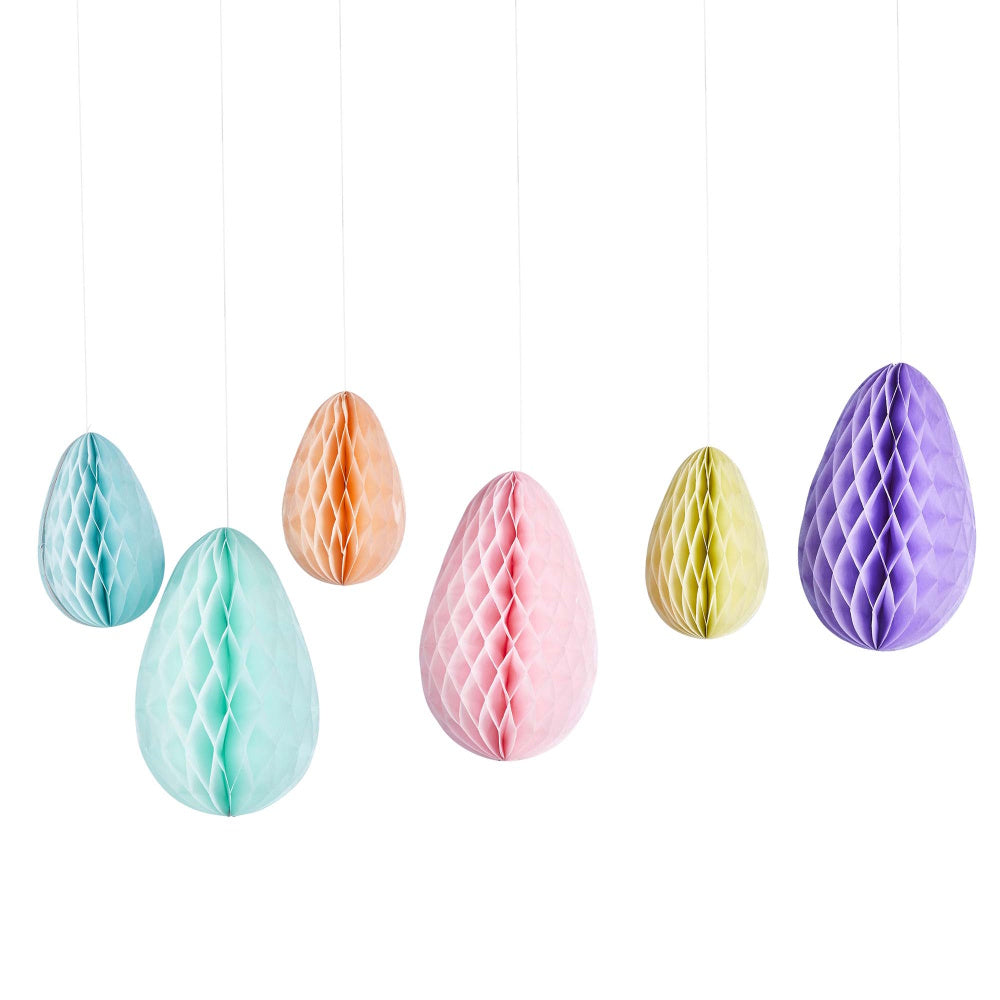 Pastel-colored honeycomb Easter egg decorations hanging against a white background