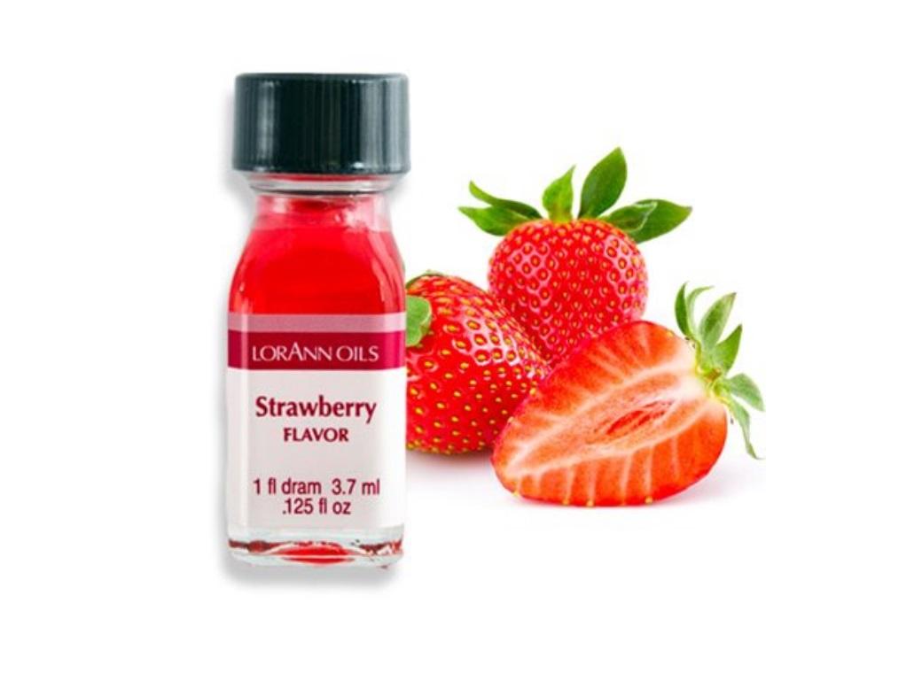 A bottle of Lorann Oils Strawberry Flavouring with fresh strawberries in the background.